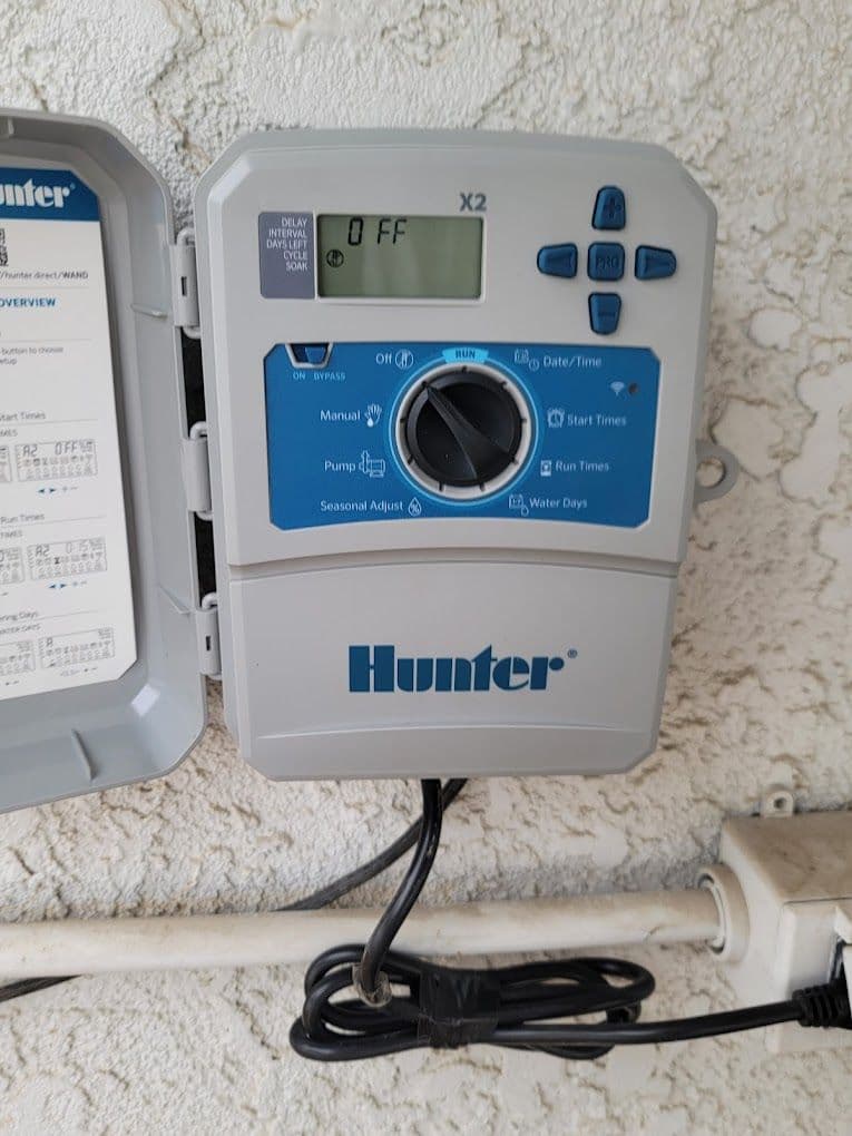 Hunter irrigation controller with digital display and settings for watering schedules.