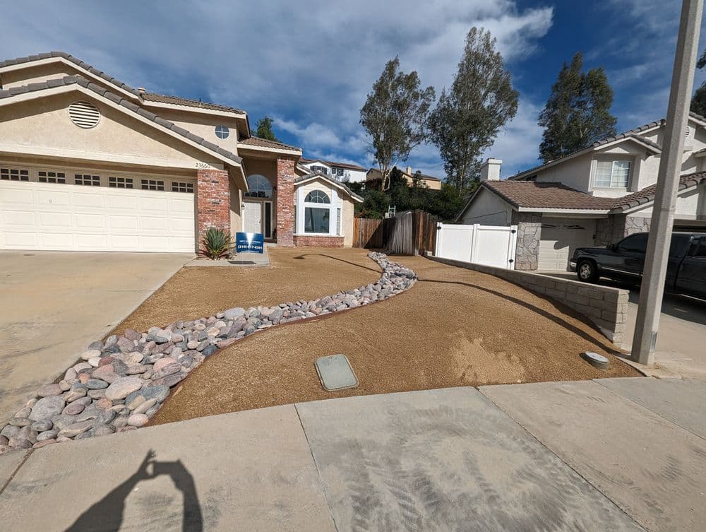 Desert landscape design featuring gravel, decorative rocks, and a residential home exterior.