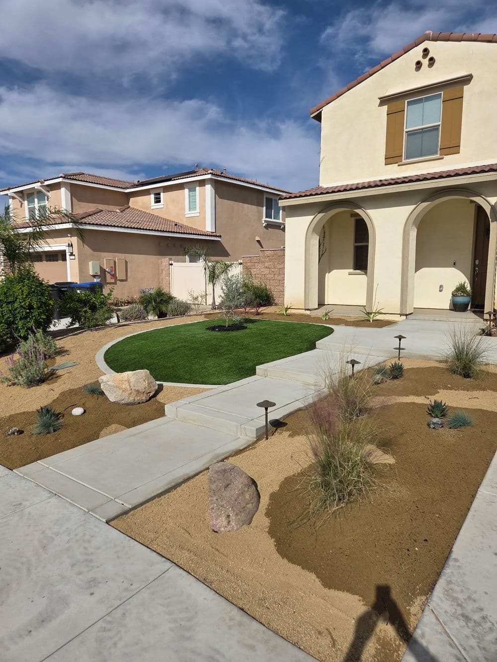Brick home with green grass and a blue cloudy sky
